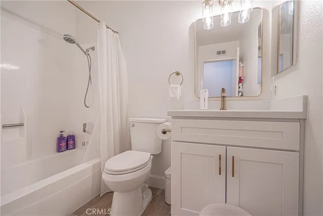 a bathroom with a sink toilet vanity and shower