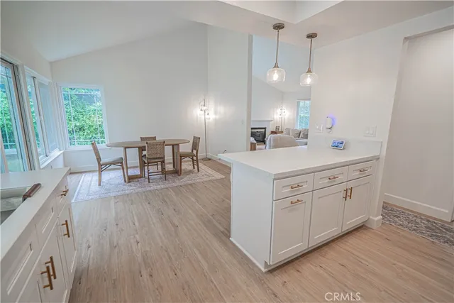 a view of a kitchen counter space wooden floor and stainless steel appliances