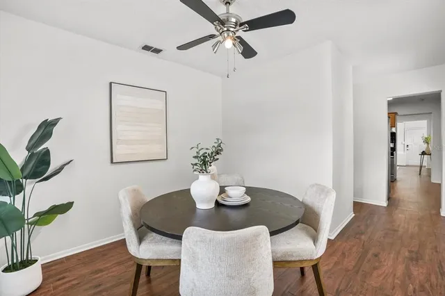 a dining room with furniture potted plants and wooden floor