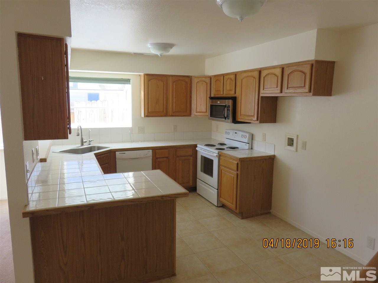591 Tarn Way Reno, NV 89503 - Photo 3 of 8 a kitchen with stainless steel appliances granite countertop a sink stove and refrigerator