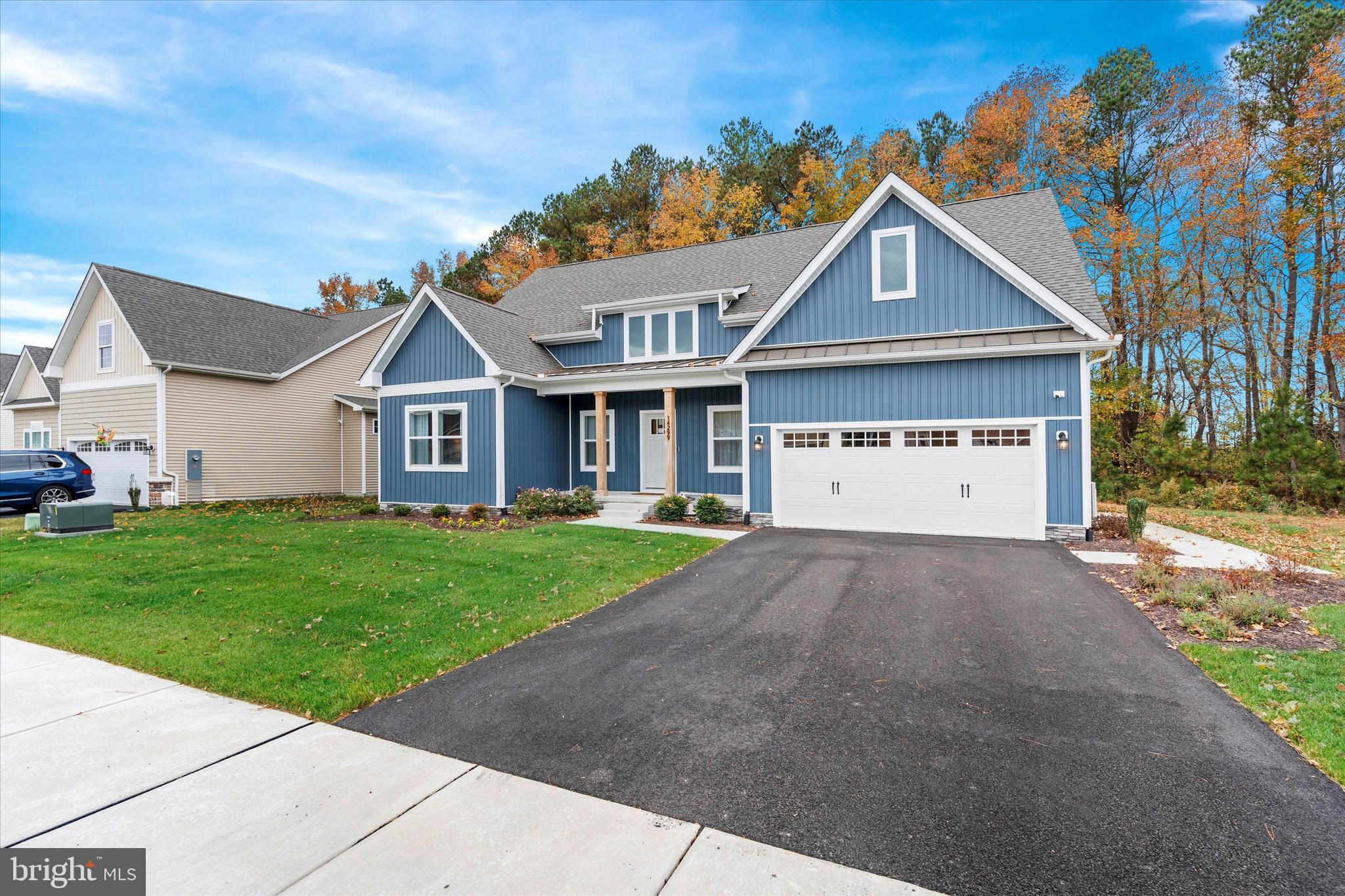 a view of a yard in front of a house with a large tree