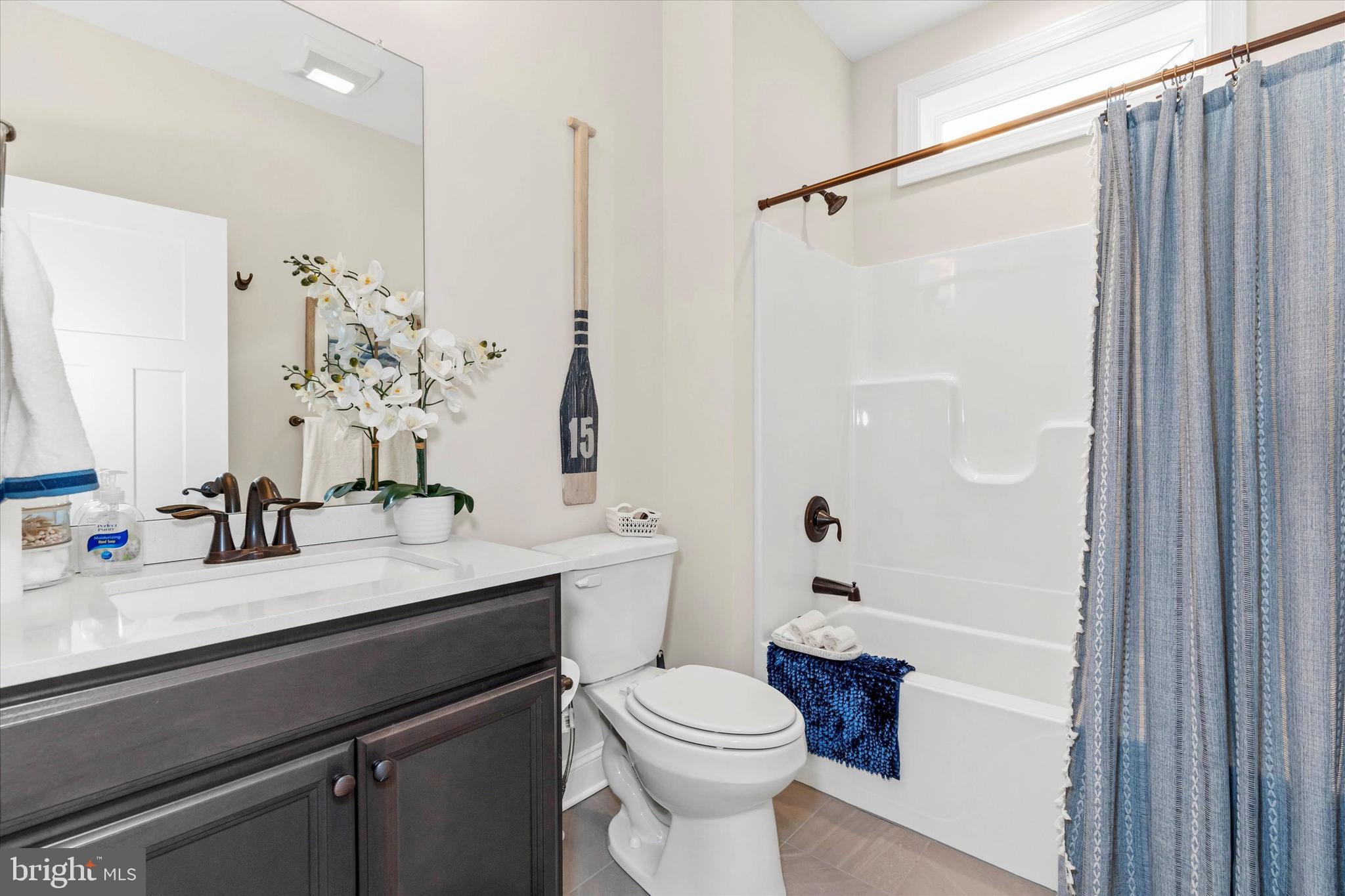 25021 Trinity Road, Unit 83 Lincoln, DE 19960 - Photo 25 of 42 a bathroom with a sink a toilet a mirror and shower