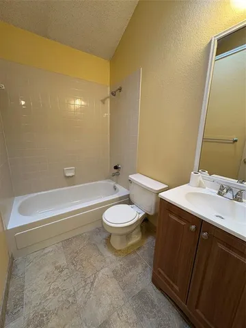 a bathroom with a granite countertop sink toilet and a mirror