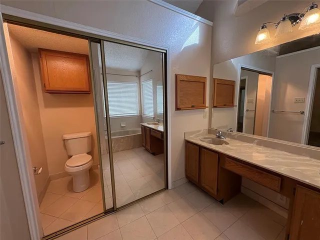 a spacious bathroom with a granite countertop sink and a mirror