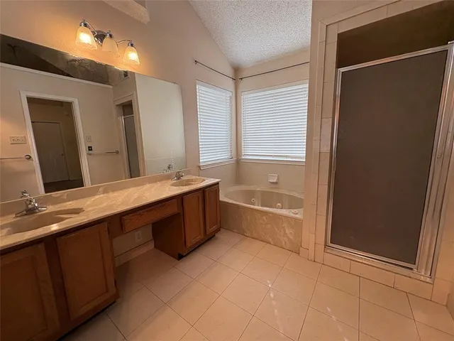 a bathroom with a granite countertop sink a mirror and a bathtub