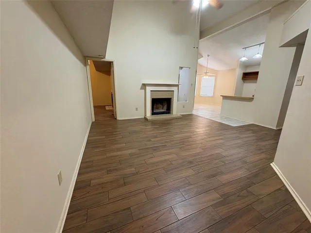 a view of a hallway with wooden floor and a fireplace