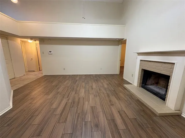 a view of empty room with wooden floor and fireplace