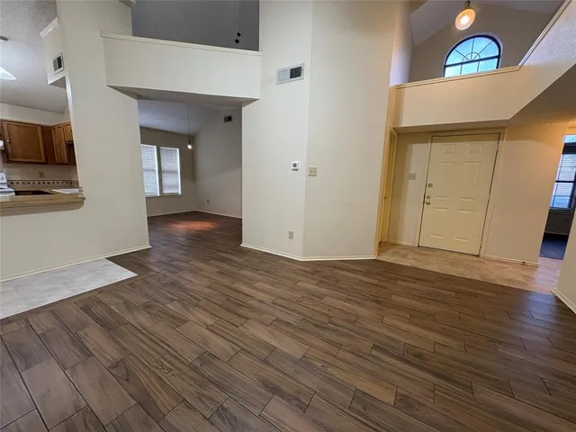 a view of empty room with wooden floor