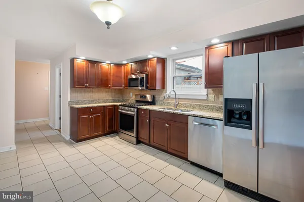 a kitchen with stainless steel appliances a sink and a refrigerator