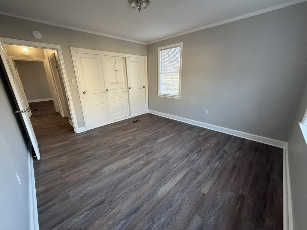 994 Hale Road Memphis, TN 38116 - Photo 18 of 24 Unfurnished bedroom featuring dark wood finished floors, ornamental molding, and a closet