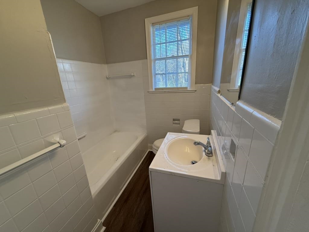 994 Hale Road Memphis, TN 38116 - Photo 19 of 24 Bathroom with tile walls, wainscoting, vanity, a bathtub, and dark wood-type flooring