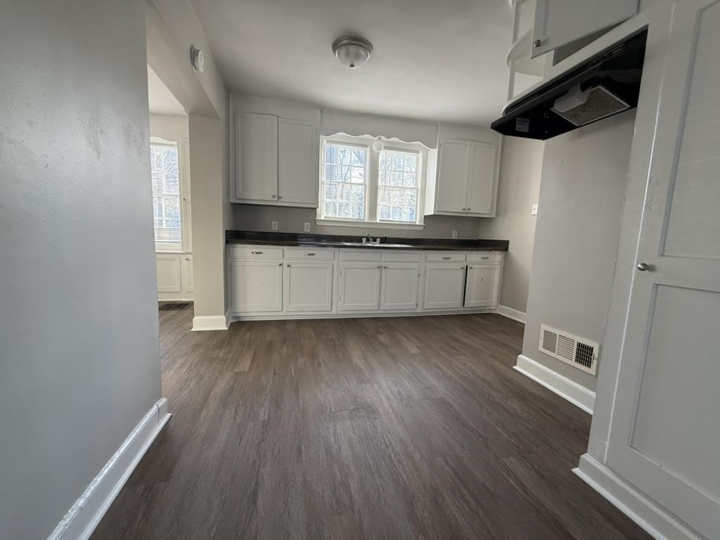 994 Hale Road Memphis, TN 38116 - Photo 4 of 24 Kitchen featuring dark countertops, ventilation hood, dark wood finished floors, and white cabinets