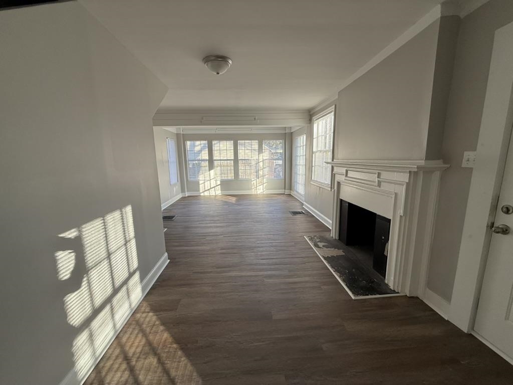 994 Hale Road Memphis, TN 38116 - Photo 8 of 24 Unfurnished living room with a fireplace, dark wood-style flooring, and crown molding