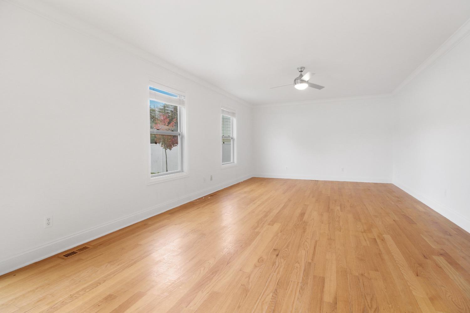 12465 Shelby Place Crown Point, IN 46307 - Photo 13 of 25 an empty room with wooden floor and windows