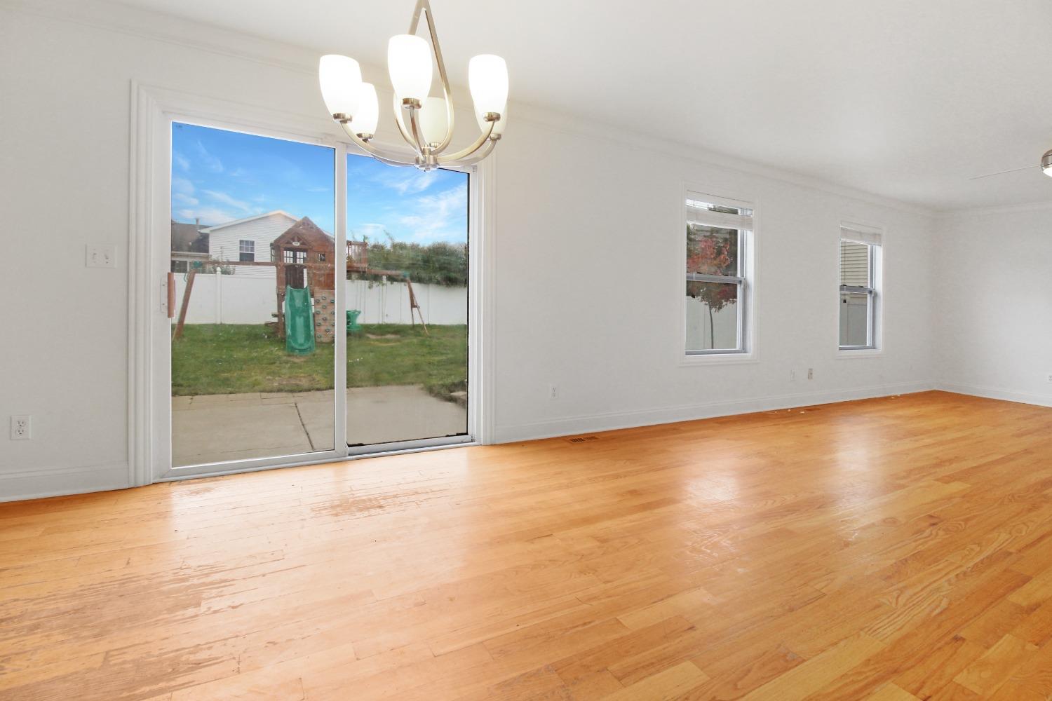 12465 Shelby Place Crown Point, IN 46307 - Photo 14 of 25 a view of an empty room with a window and wooden floor