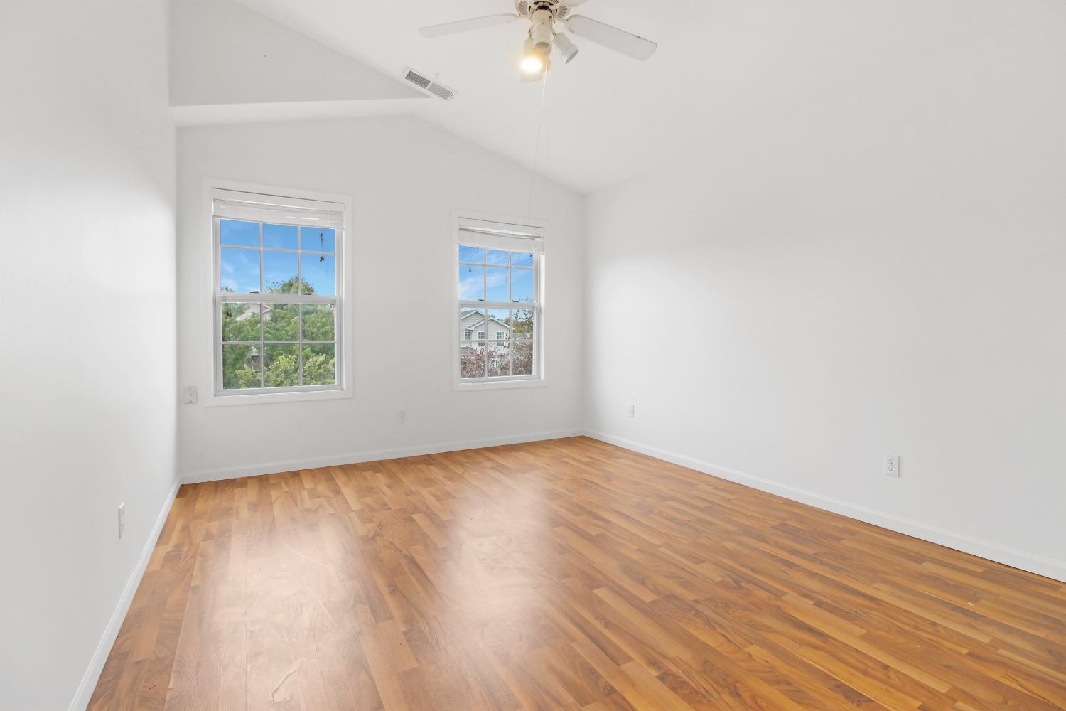 12465 Shelby Place Crown Point, IN 46307 - Photo 19 of 25 an empty room with wooden floor chandelier fan and windows