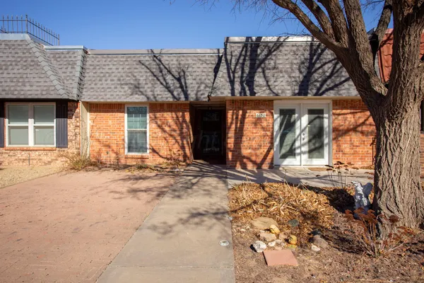 a front view of a house with a yard covered in snow