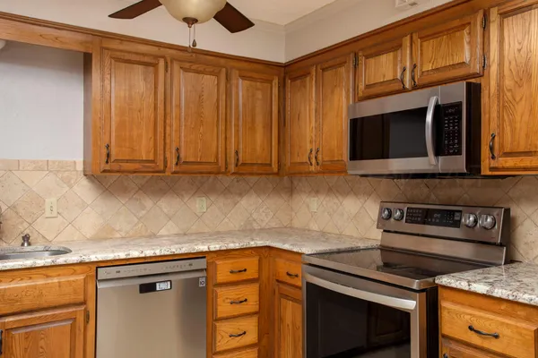 a kitchen with stainless steel appliances granite countertop a stove microwave and cabinets