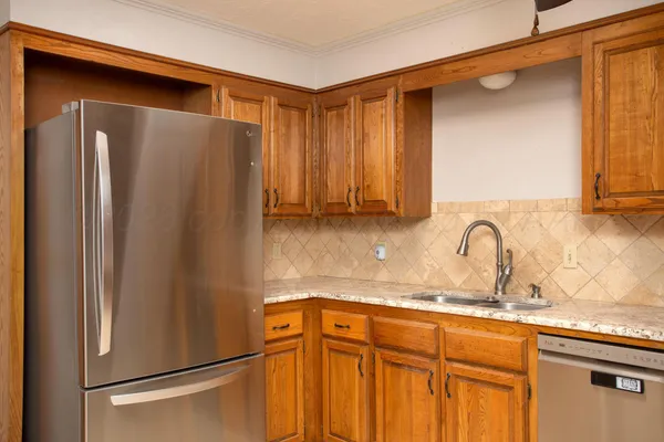 a kitchen with stainless steel appliances granite countertop a refrigerator and a sink