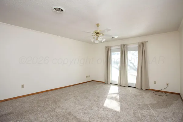 an empty room with chandelier fan