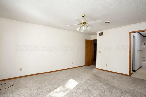 an empty room with a ceiling fan and a window