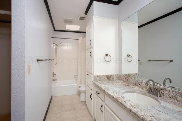 a bathroom with a granite countertop sink a mirror and a shower