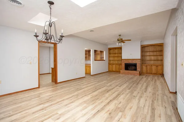 a view of empty room with wooden floor and fireplace
