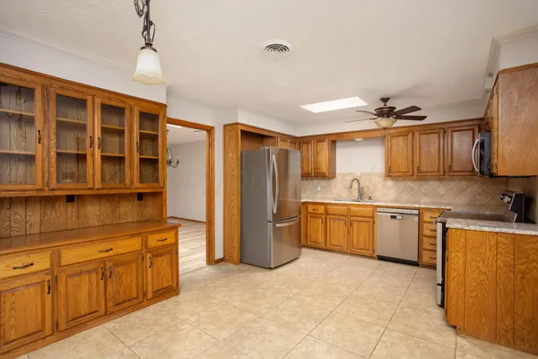 a kitchen with a refrigerator sink and wooden cabinets