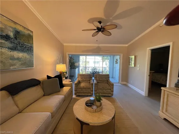a living room with furniture a ceiling fan and a window