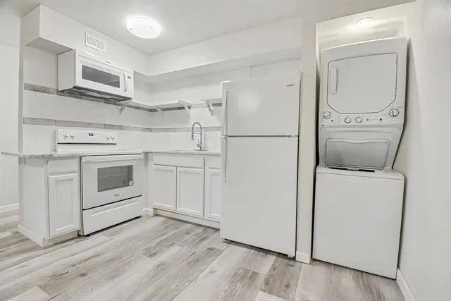 a view of an empty room with fire place and a window