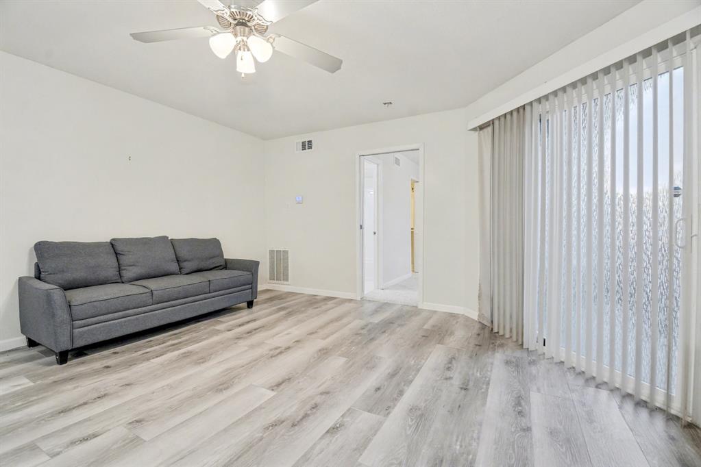 9815 Walnut Street, Unit H306 Dallas, TX 75243 - Photo 4 of 23 a living room with furniture and a chandelier