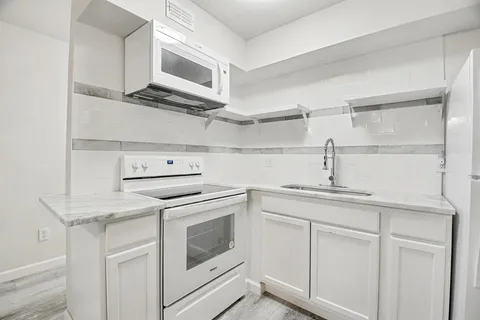a view of a kitchen with a sink cabinets and a ceiling fan