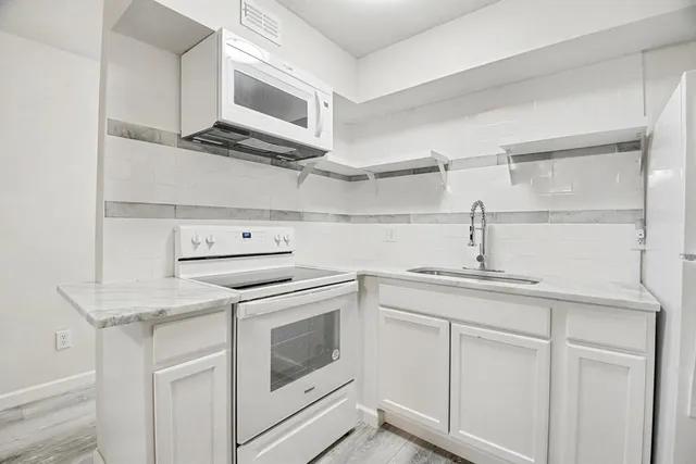 a view of a kitchen with a sink cabinets and a ceiling fan