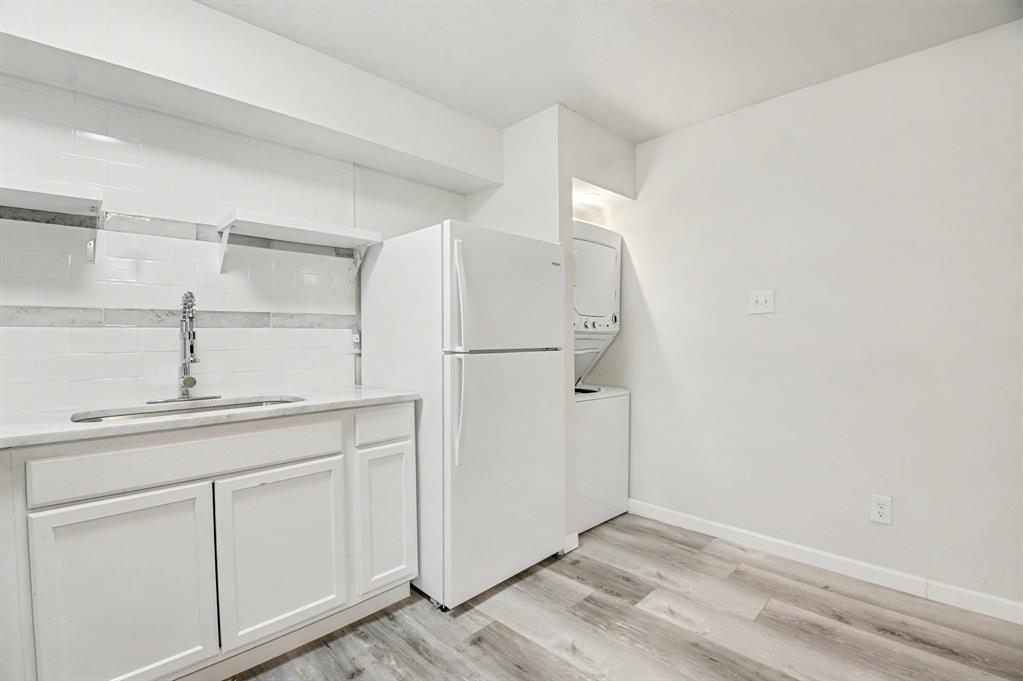 9815 Walnut Street, Unit H306 Dallas, TX 75243 - Photo 8 of 23 a kitchen with cabinets and a refrigerator