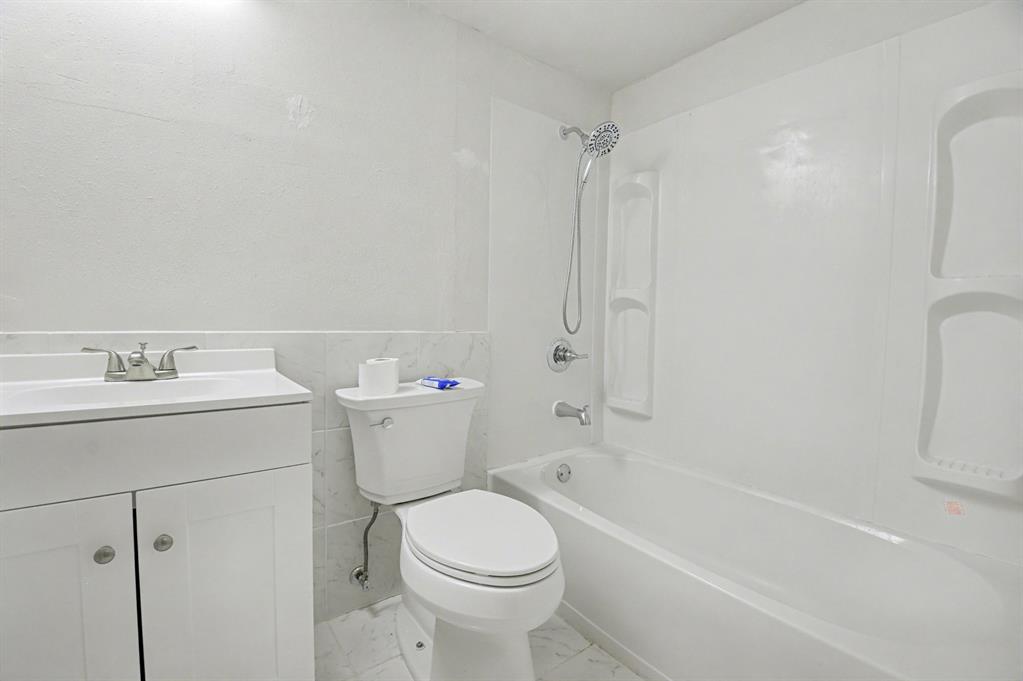 9815 Walnut Street, Unit H306 Dallas, TX 75243 - Photo 9 of 23 a bathroom with a sink a toilet and bathtub