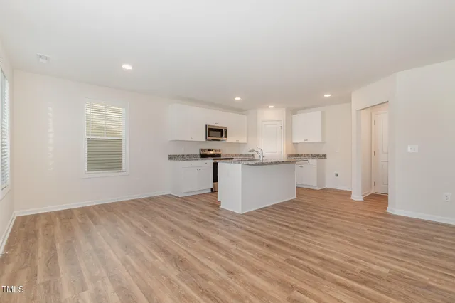 a view of kitchen with granite countertop cabinets and refrigerator