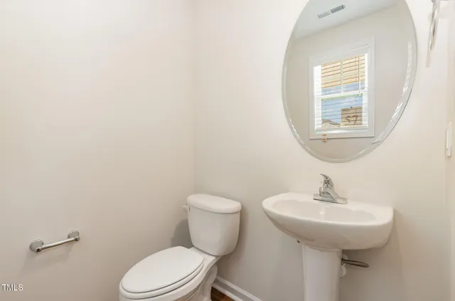 a bathroom with a sink a mirror and a toilet