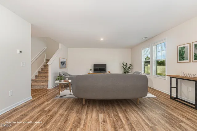 a living room with furniture and a wooden floor