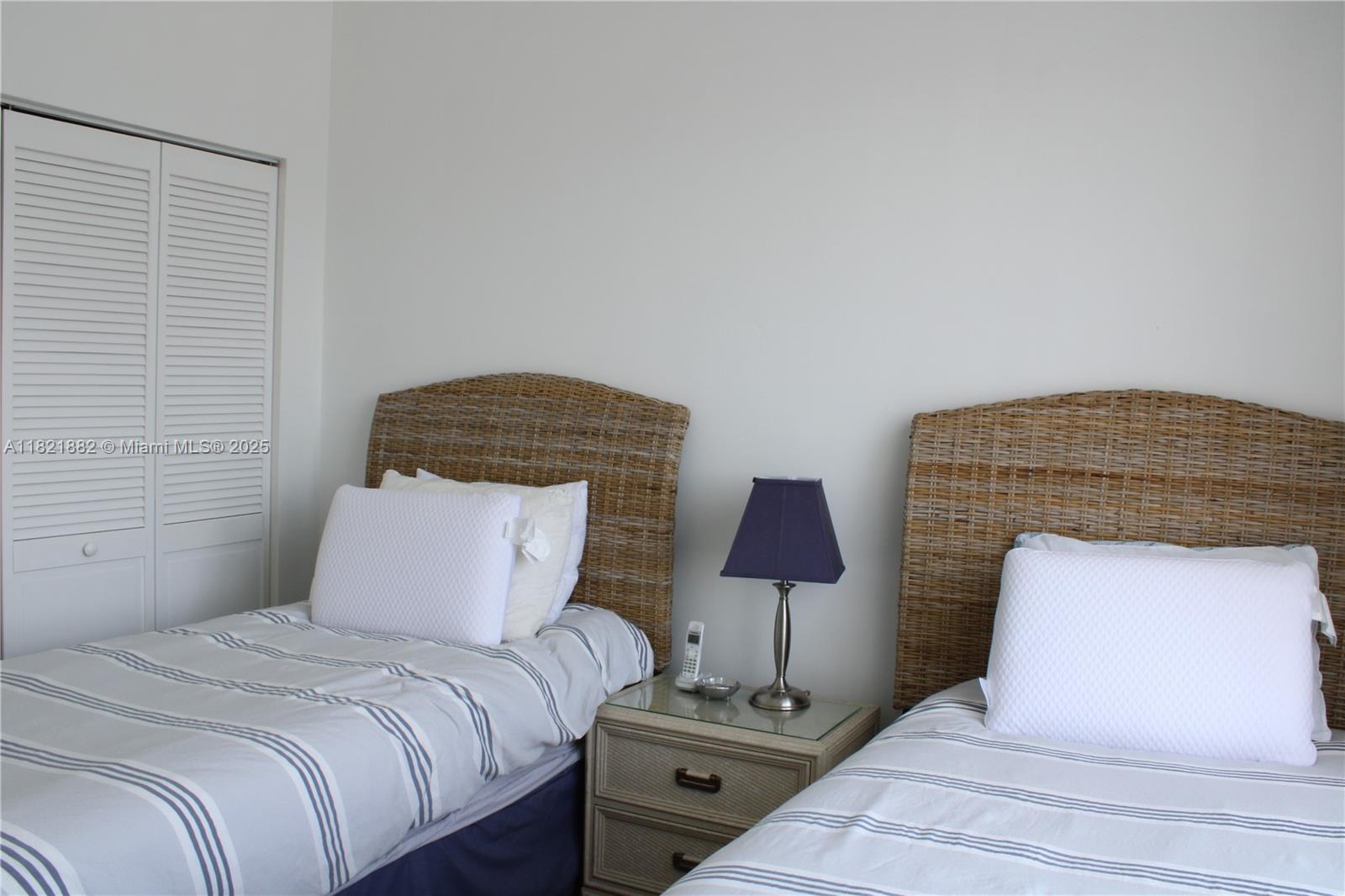 201 Crandon Boulevard, Unit 439 Key Biscayne, FL 33149 - Photo 13 of 24 a bedroom with a bed and a lamp