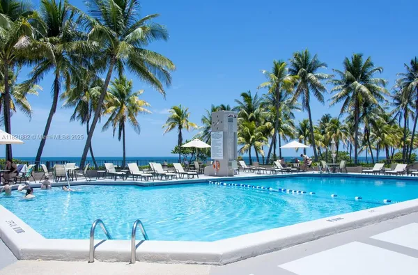 a view of a swimming pool with a patio and a yard
