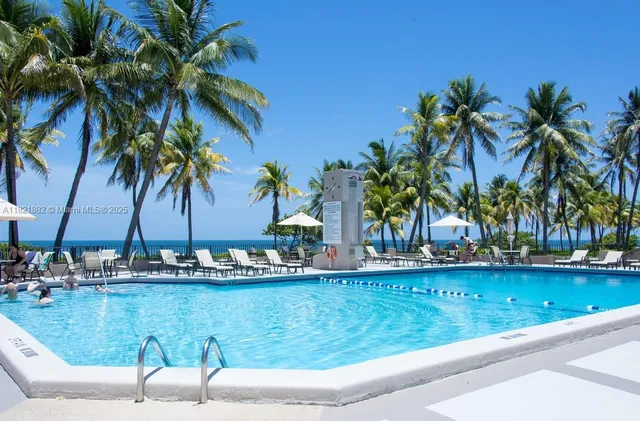 a view of a swimming pool with a patio and a yard
