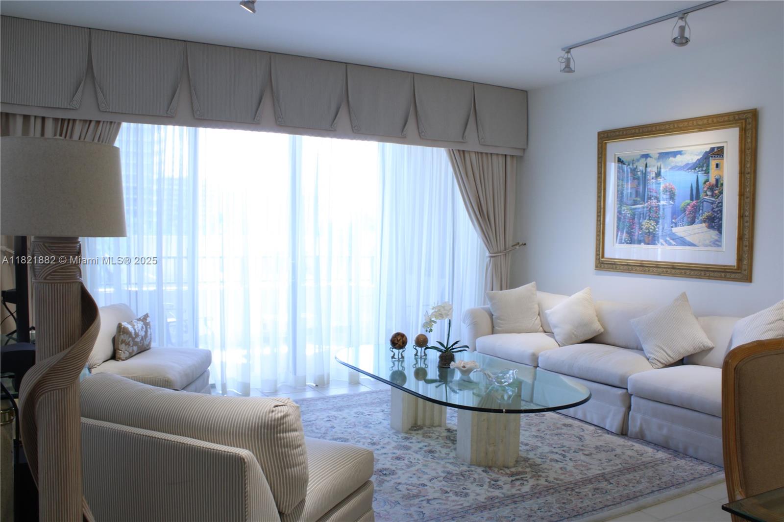 201 Crandon Boulevard, Unit 439 Key Biscayne, FL 33149 - Photo 5 of 24 a living room with furniture and a large window