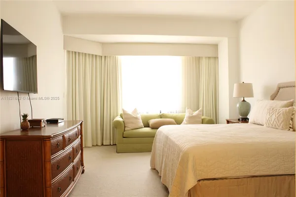 a bedroom with bed and a flat screen tv