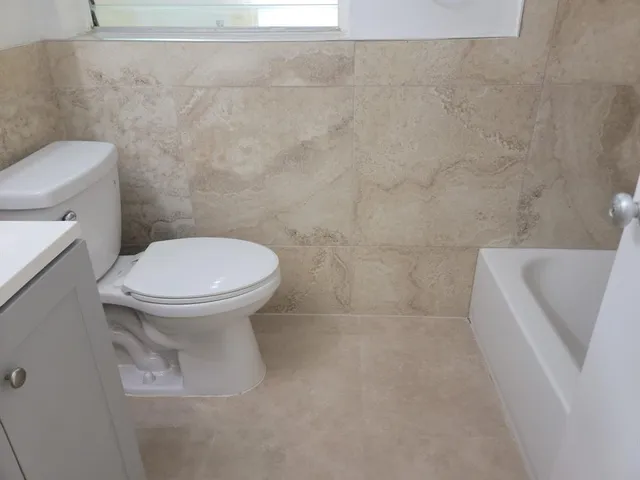 a white toilet sitting next to a bath tub