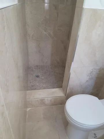 a white toilet sitting next to a bath tub