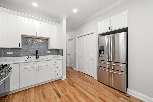 a kitchen with white cabinets and stainless steel appliances