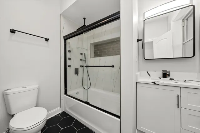 a bathroom with a granite countertop sink toilet and shower