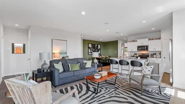 a kitchen with a dining table chairs and refrigerator