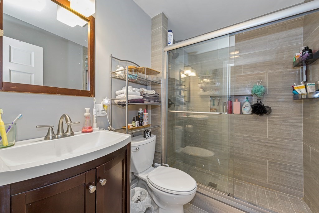 16 Sewall Street Boston, MA 02120 - Photo 20 of 42 a bathroom with a sink a toilet a glass door shower and mirror