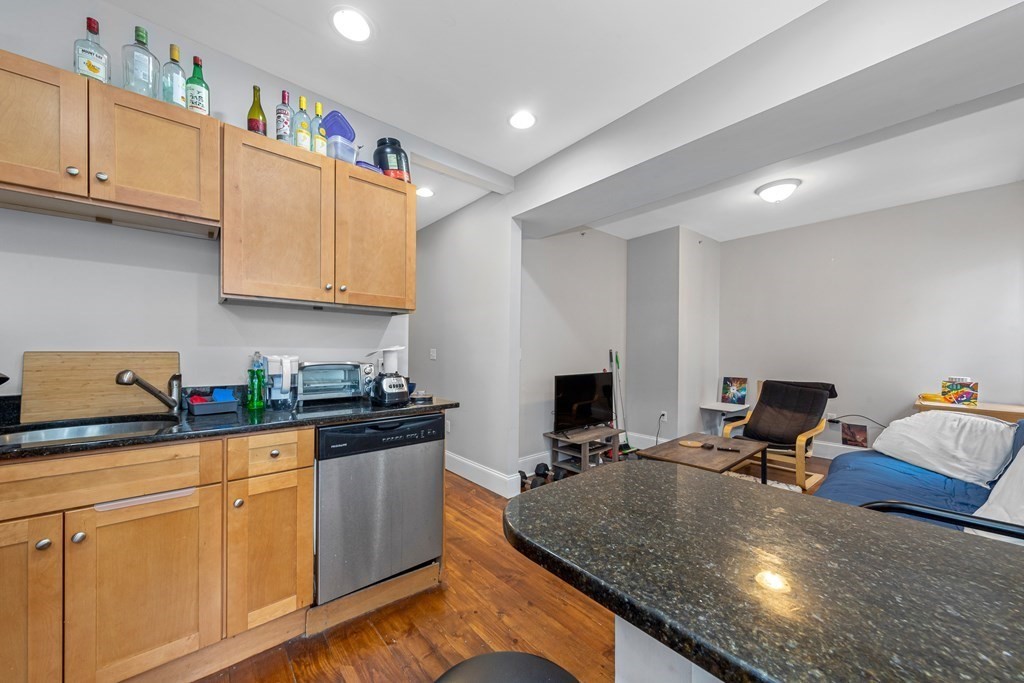 16 Sewall Street Boston, MA 02120 - Photo 29 of 42 a kitchen with stainless steel appliances granite countertop a stove top oven a sink dishwasher and cabinets with wooden floor